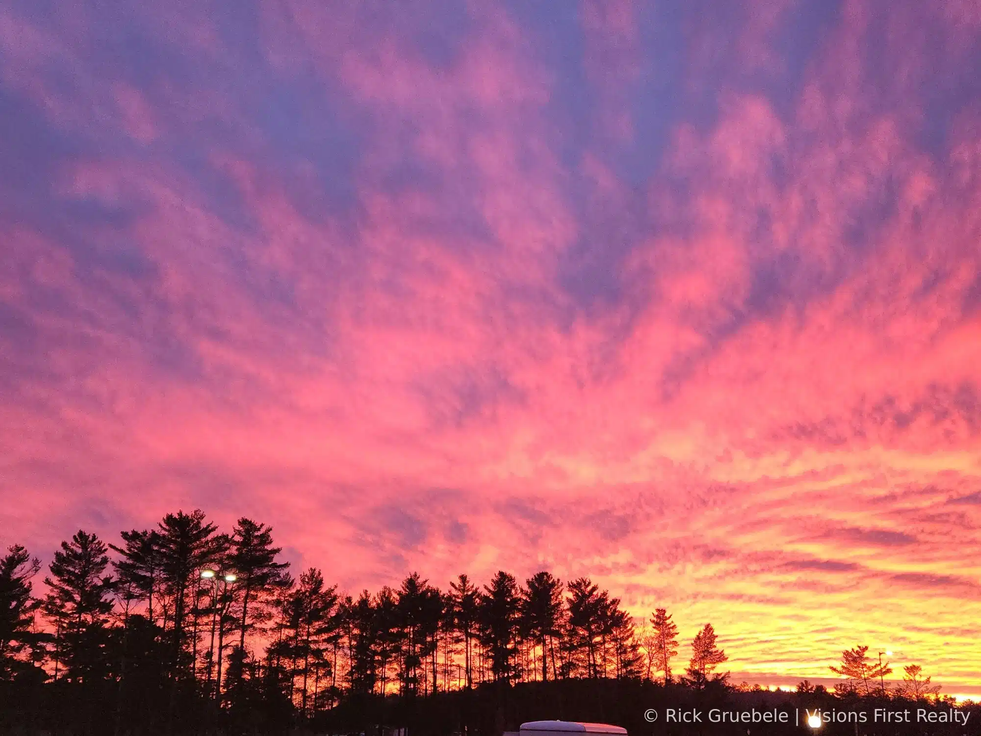 Northwoods sunset through pine trees — Ashland County WI real estate