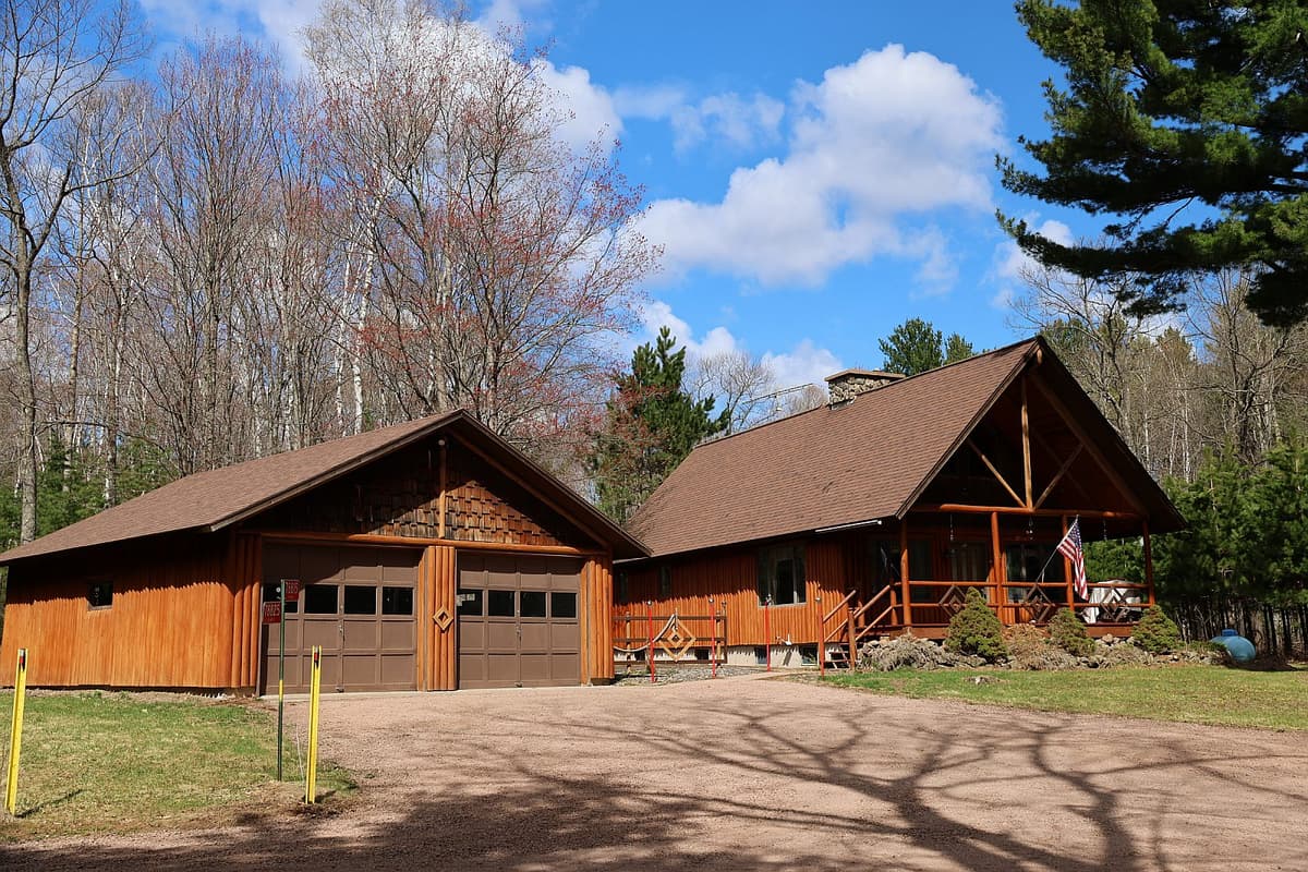 Log home exterior at 78815 State Hwy 13, Washburn WI, showing the front of the 1987-built log cabin set among mature pines